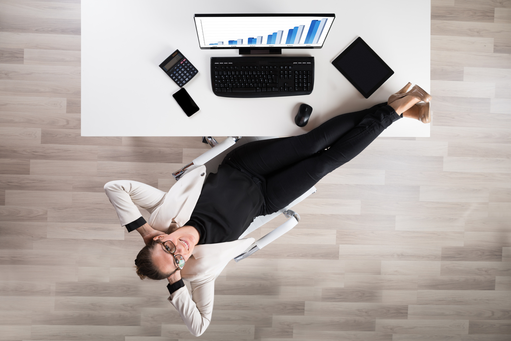 High Angle View Of Happy Businesswoman Relaxing On Chair In Office